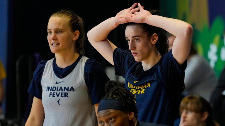 Indiana Fever guard Caitlin Clark, top right, watches from the...