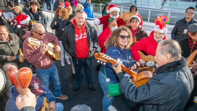 Carolers from the Puerto Rican Coalition for a Better Community sing...