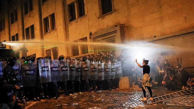 A demonstrator gestures trying to stop riot police during an...