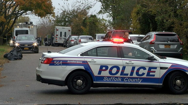 Suffolk County Police Homicide Squad detectives work the scene around Sinn...
