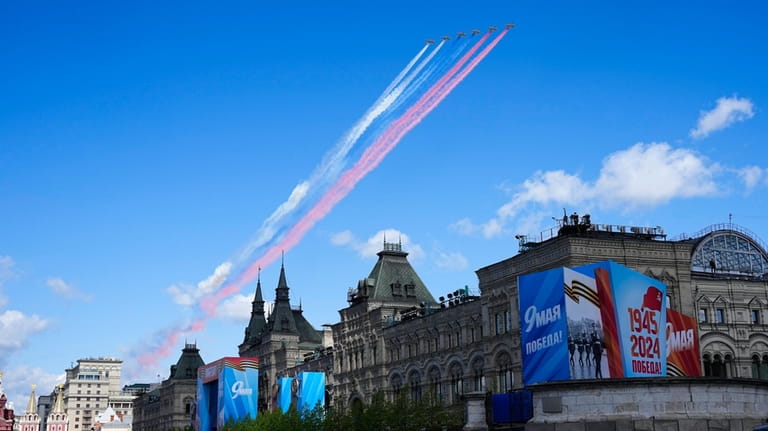 Russian military planes fly over Red Square leaving trails of...