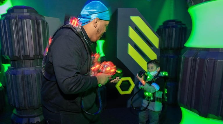 Matthew Ticona, 6, of Uniondale, laser tags with Tavin Bell, 20, of...