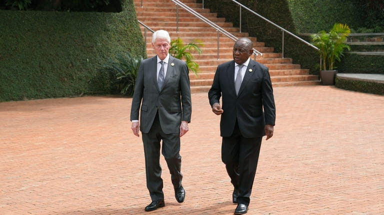 Former US President Bill Clinton, left, and South Africa's President...