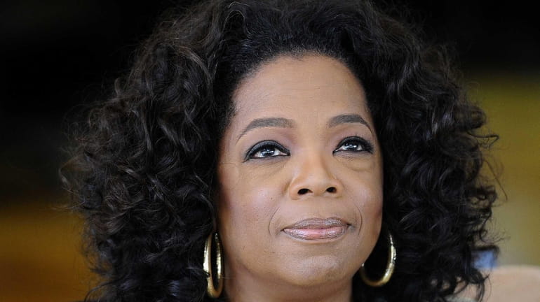 Oprah Winfrey looks on as she answers journalist's questions at...