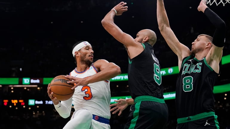 Knicks guard Josh Hart looks to pass while covered by...