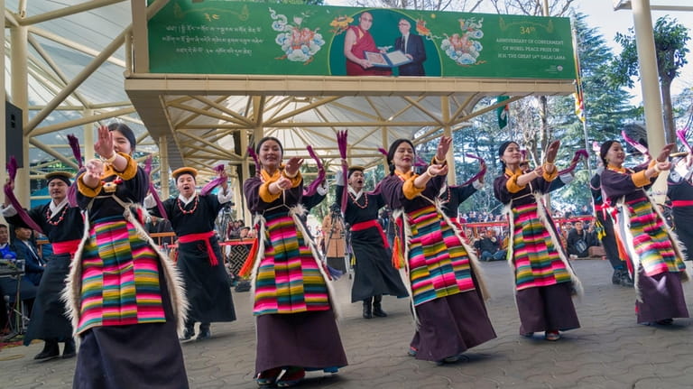 Exile Tibetan artists perform a traditional dance as they mark...