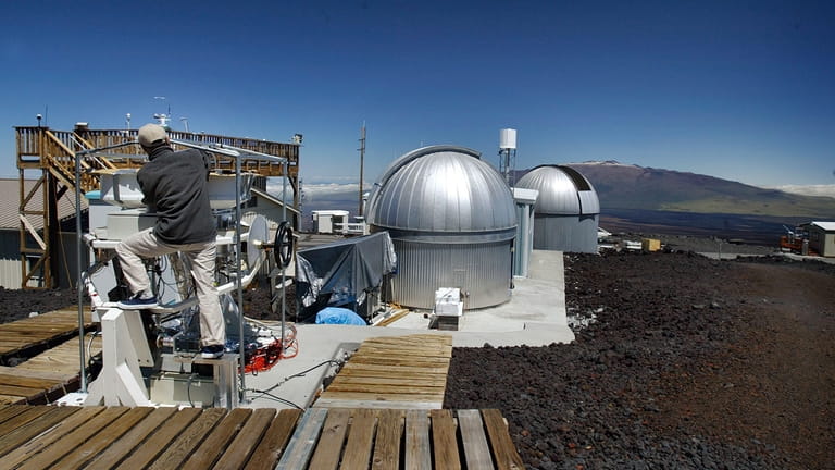 A scientist works at Hawaii's Mauna Loa Observatory at 3396...