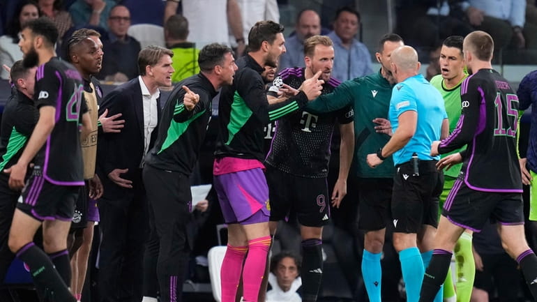 Bayern Munich players argues with referee Szymon Marciniak at the...