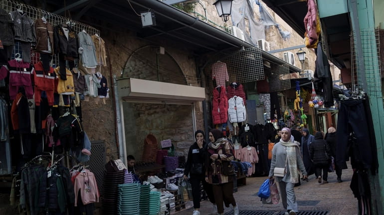 File - Muslim women walk through a market, ahead of...