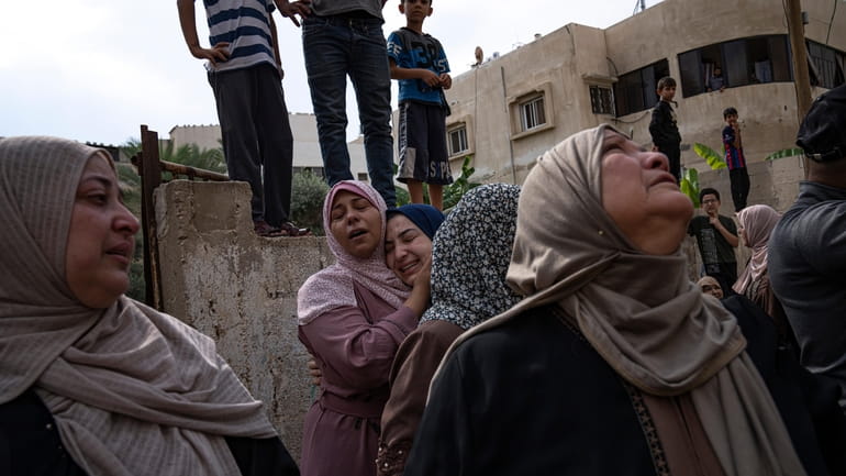 Relatives mourn people killed in an Israeli air strike in...