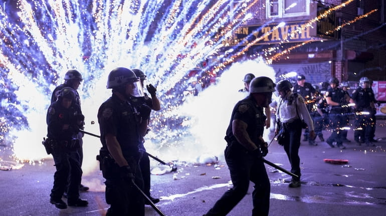 A firework goes off near NYPD cops during a protest...