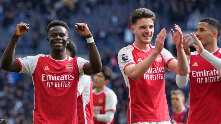 Arsenal's Bukayo Saka and Declan Rice celebrate at the end...