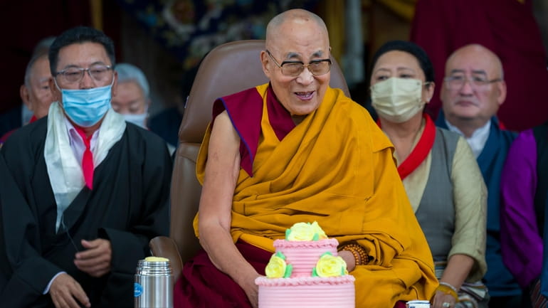 Tibetan spiritual leader the Dalai Lama smiles as he presides...