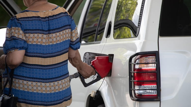 A customer pumps a gas at a station on Elmont...