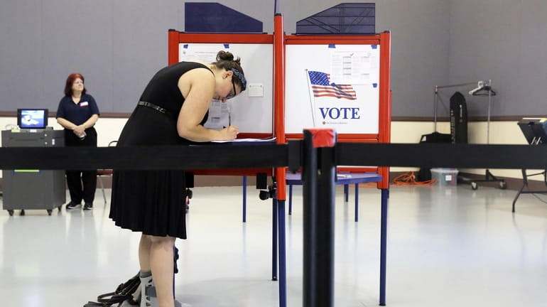 A voter fills out a ballot at a polling station...