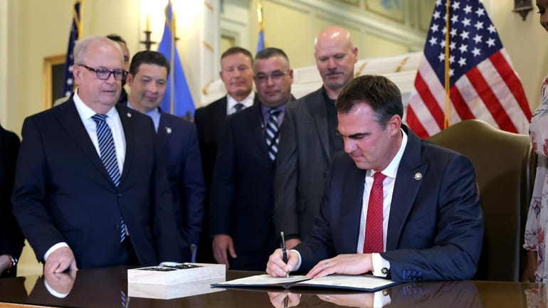 Oklahoma Gov. Kevin Stitt signs an executive order in the...