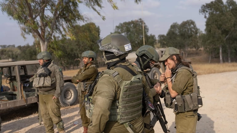 Israeli soldiers gather near the Israeli-Gaza border in southern Israel...
