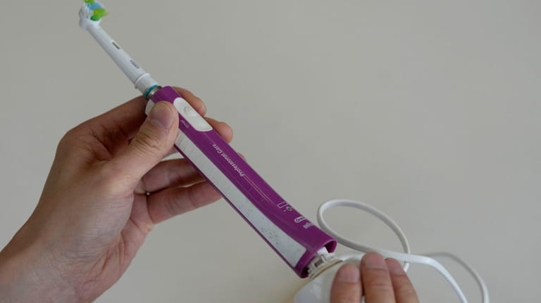 Dismantling an electric toothbrush by twisting the docking station in...