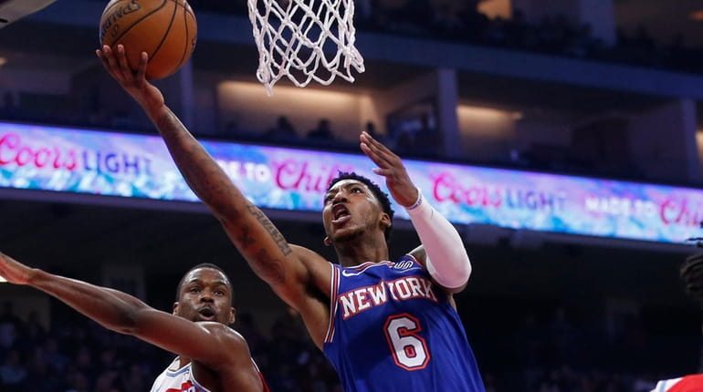 Knicks guard Elfrid Payton, center, goes to the basket between...