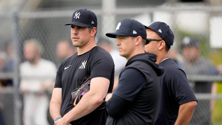Yankees pitcher Carlos Rodon, left, watches a spring training workout...