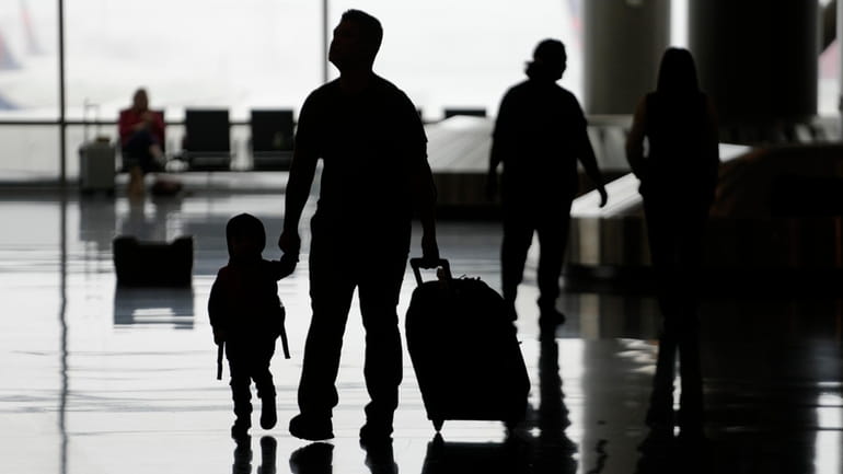 People travel through Salt Lake City International Airport on Wednesday,...