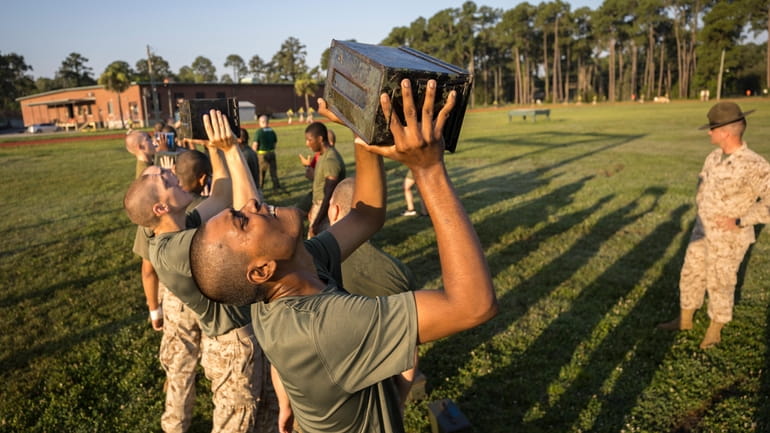 A group of male U.S. Marine Corps recruits train with...