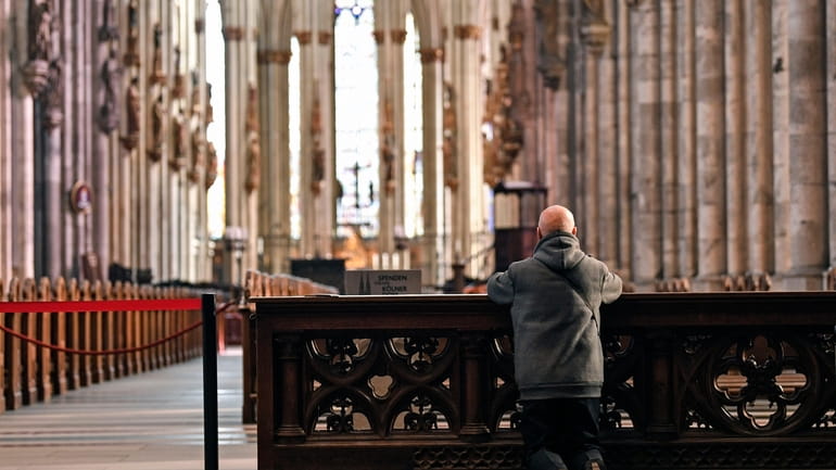 A man prays in the empty world famous Cologne Cathedral...