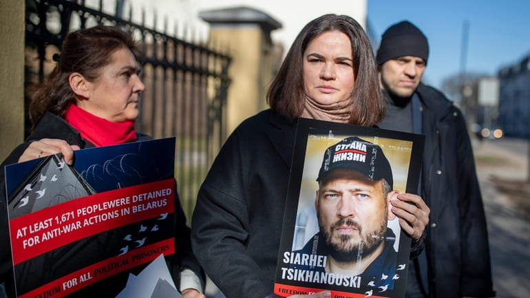 Belarusian opposition leader Sviatlana Tsikhanouskaya, centre, holds a portrait of...