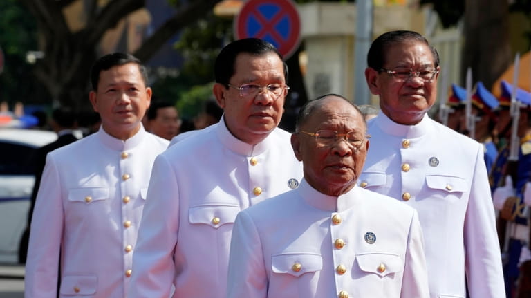 President of the National Assembly Heng Samrin, front, walks together...
