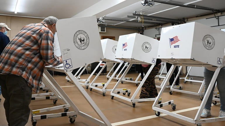 Voters cast their vote at the voting polls at the...