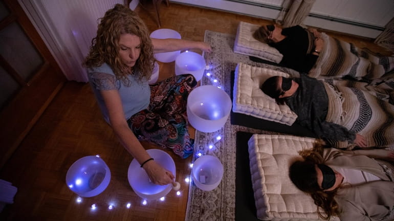 Jenn Foote uses crystal singing bowls to create meditative sounds at...