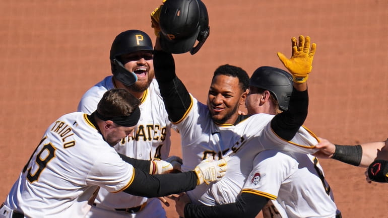 Pittsburgh Pirates' Edward Olivares, center, celebrates after hitting a walk-off...