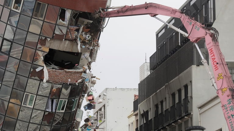 Heavy equipment begins demolition of a collapsed building, two days...