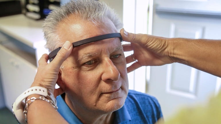 Ron Mirro has a brain sensor placed on his head...