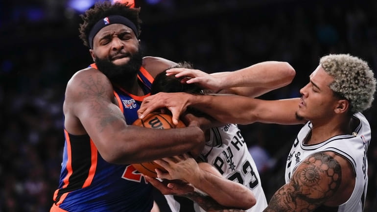 New York Knicks' Mitchell Robinson, left, tries to grab the...