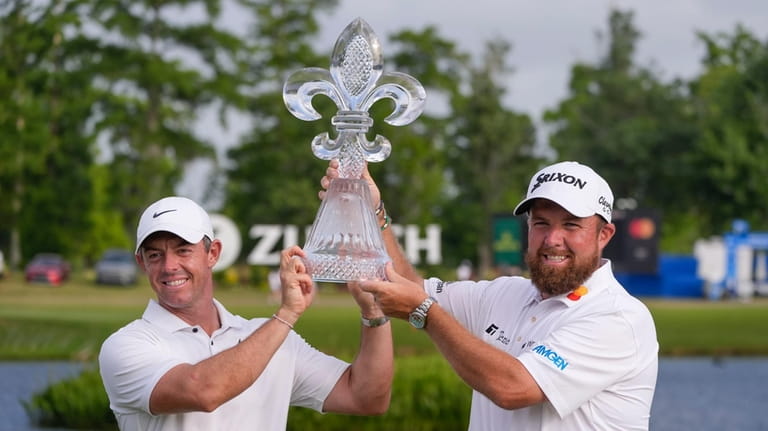 Rory McIlroy, of Northern Ireland, and teammate Shane Lowry, of...