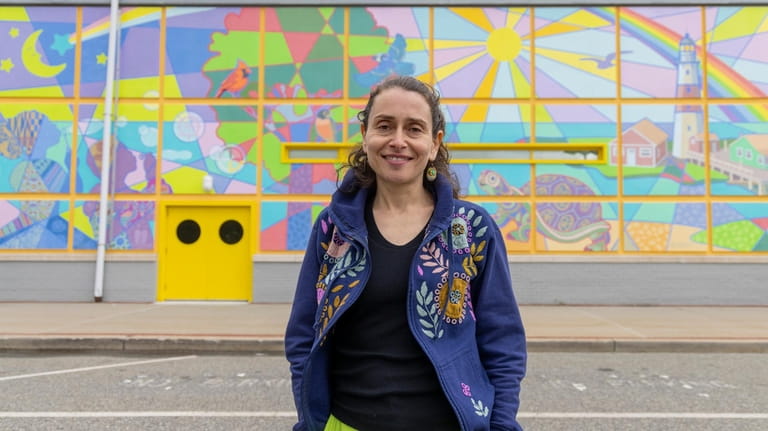 Muralist Viktoriya Basina stands in front of the new mural...