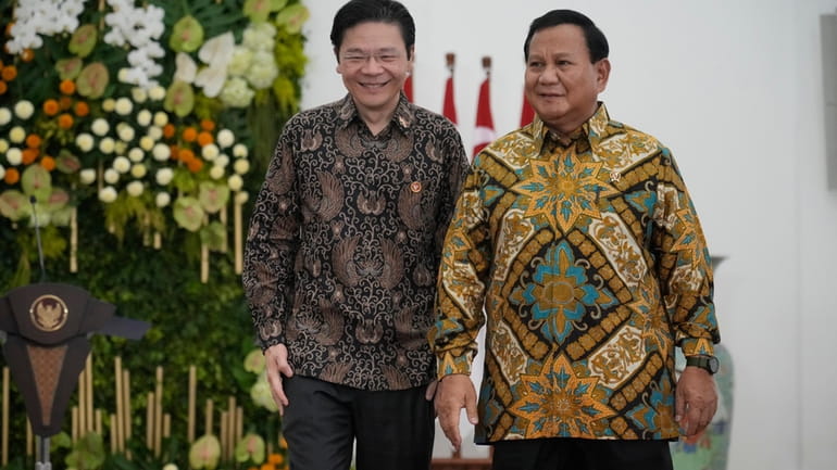 Indonesian Defense Minister and president-elect Prabowo Subianto, right, and Singapore's...