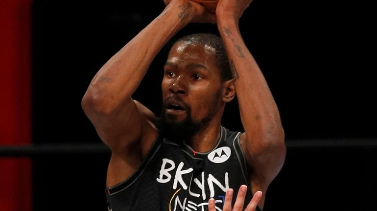 Kevin Durant of the Nets hits a three-point shot during...
