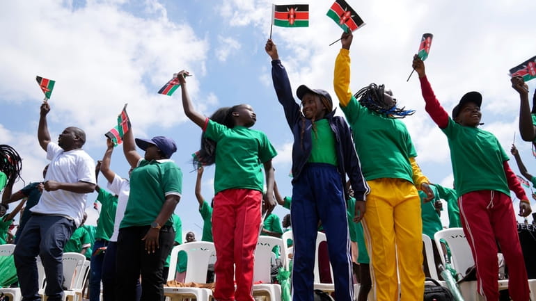 People jump and wave Kenyan flags during the 60th Jamhuri...