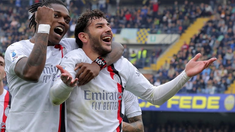 Milan's Theo Hernandez, right, celebrates after scoring the opening goal...