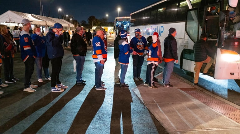 New York Islanders fans board a shuttle bus after leaving...
