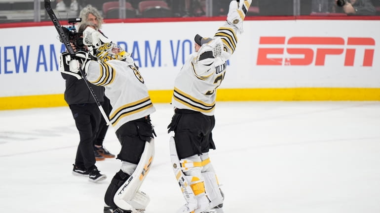Boston Bruins goaltenders Jeremy Swayman, left, Linus Ullmark celebrate after...