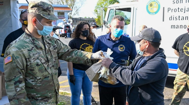 A member of the U.S. Army gives food and gloves...