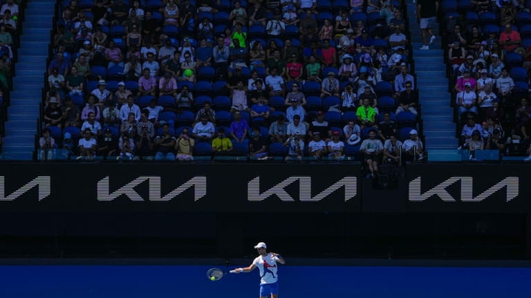 Spectators watch as Serbia's Novak Djokovic practices on Rod Laver...