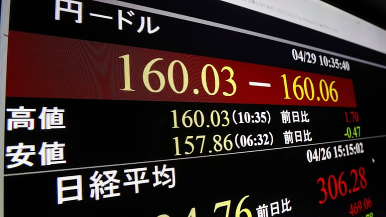 A monitor shows U.S. dollar/Japanese yen exchange rate in Tokyo...