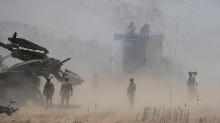 Dust billows as Philippine Army fires ATMOS 155mm howitzers during...