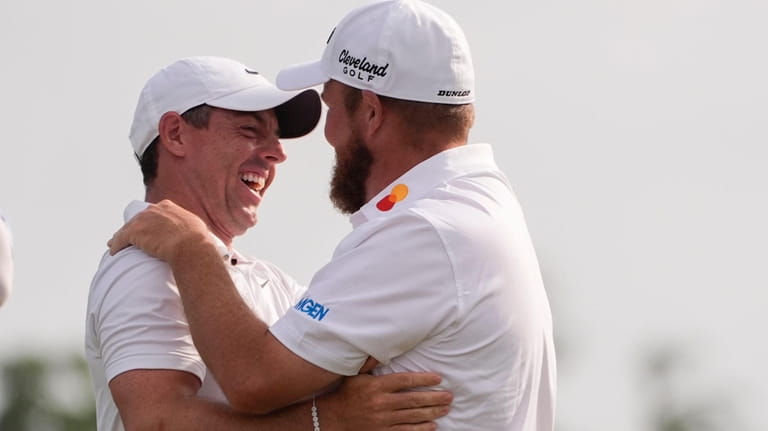 Shane Lowry, of Ireland, right, embraces his teammate Rory McIlroy,...