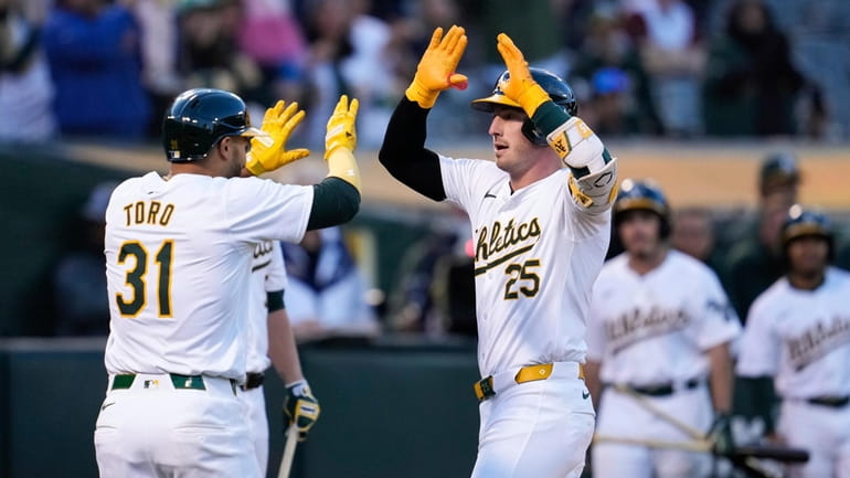 Oakland Athletics' Brent Rooker, right, celebrates with Abraham Toro after...