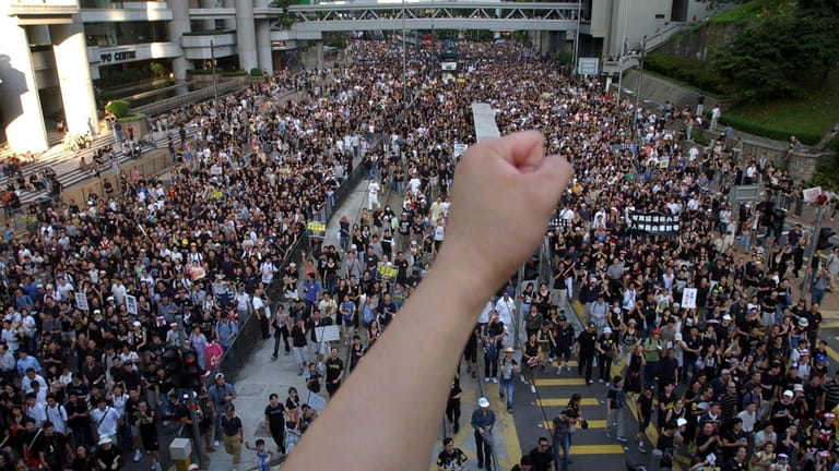 Tens of thousands of people march through a Hong Kong...